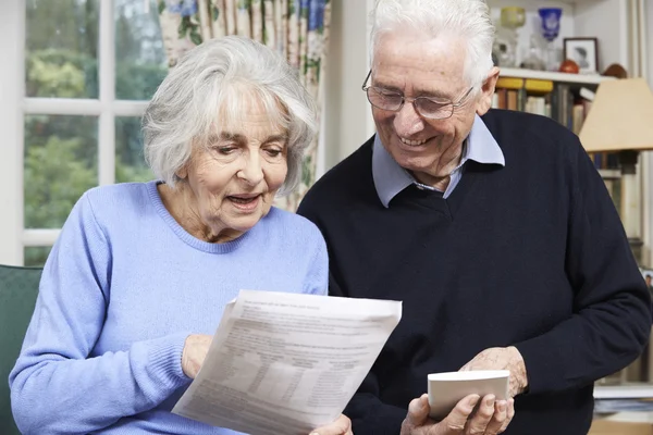 Старша пара вдома з біллями турбується про домашні фінанси — стокове фото