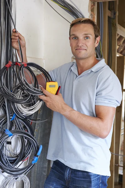 Electrician Fitting Wiring On Construction Site — Stock Photo, Image