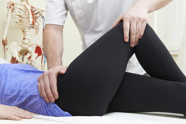 Αρσενικό Osteopath θεραπεία θηλυκό ασθενή με πρόβλημα ισχίου — Φωτογραφία Αρχείου