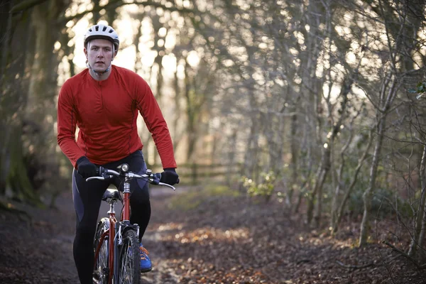 Hombre montando en bicicleta de montaña a través de bosques — Foto de Stock