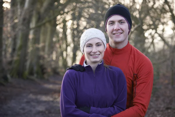 Retrato de casal no inverno correr através da floresta — Fotografia de Stock