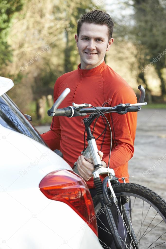 Cyclist Taking Mountain Bike From Rack On Car