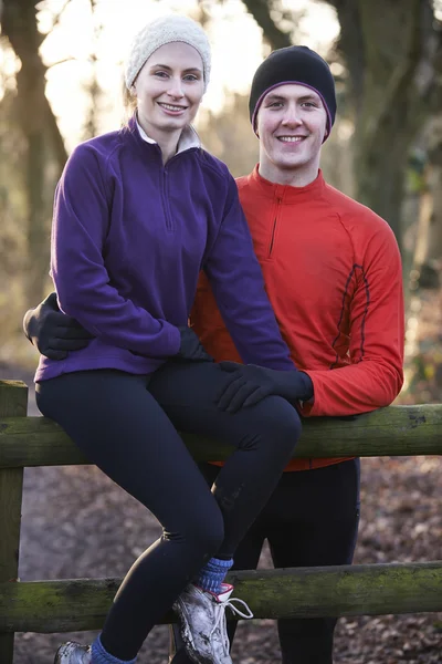 Portrait Of Couple On Winter Run Through Woodland Sitting On Fen — Stock Photo, Image