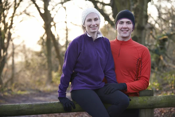 Portrait Of Couple On Winter Run Through Woodland Sitting On Fen — Stock Photo, Image