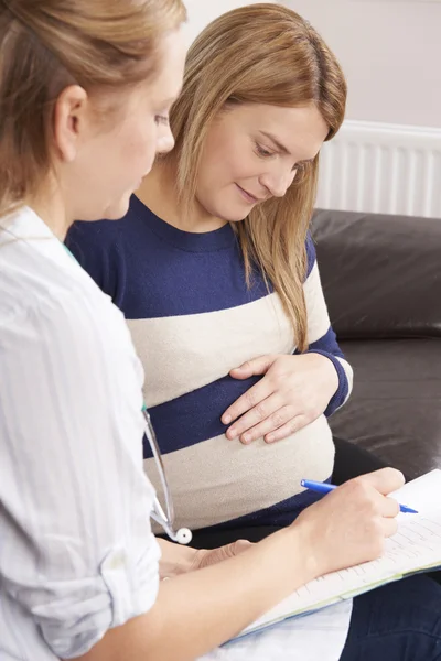 Ostetrica fare casa visita a aspettativa madre — Foto Stock