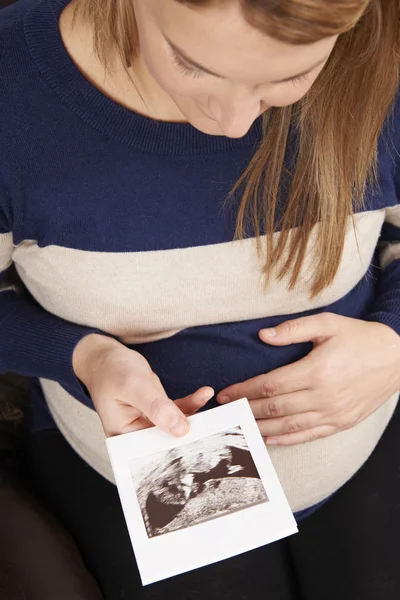 Těhotná žena při pohledu na skenování dítěte — Stock fotografie