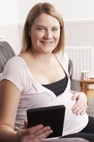 Schwangere entspannt mit E-Reader zu Hause — Stockfoto