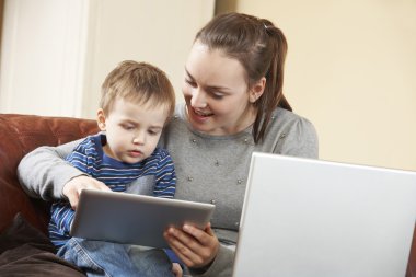 Anne oğlu dijital Tablet kullanır iken dizüstü bilgisayarda çalışma