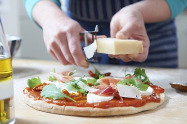 Evine maddeler ekleyerek Pizza yapılan