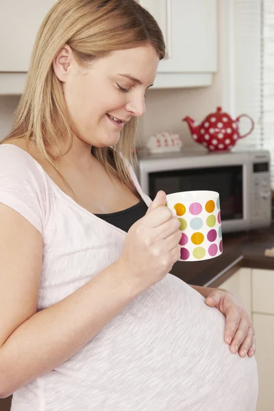 Беременная женщина расслабляется с горячим напитком — стоковое фото