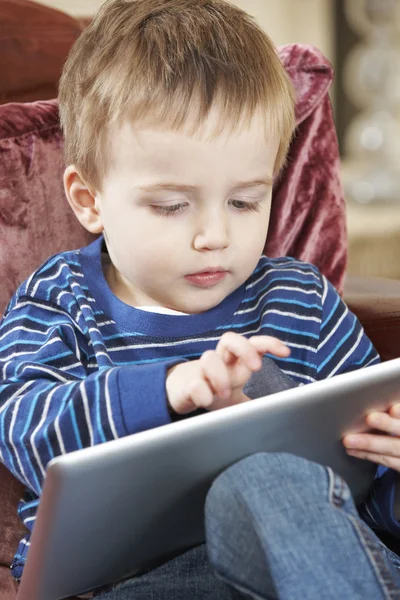 Oturan çocuk kanepe ve dijital Tablet ile çalmayı — Stok fotoğraf