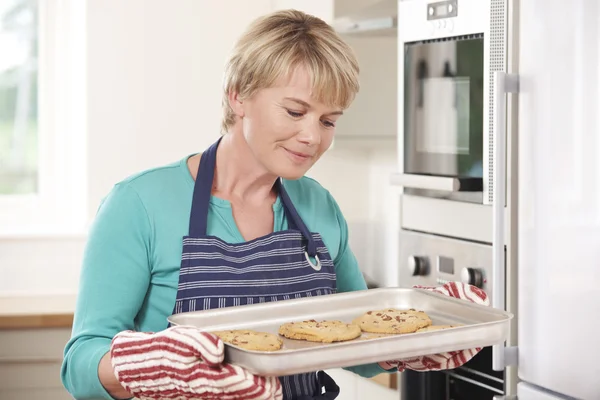 Mujer en bandeja de tenencia de cocina con galletas caseras —  Fotos de Stock