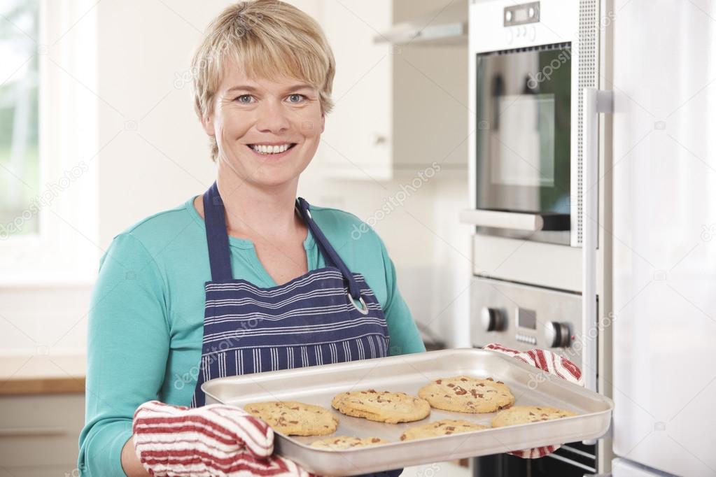 Woman In Kitchen Holding Tray With Home Baked Cookies