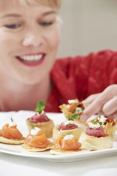 Mujer comiendo aperitivos en la placa — Foto de Stock