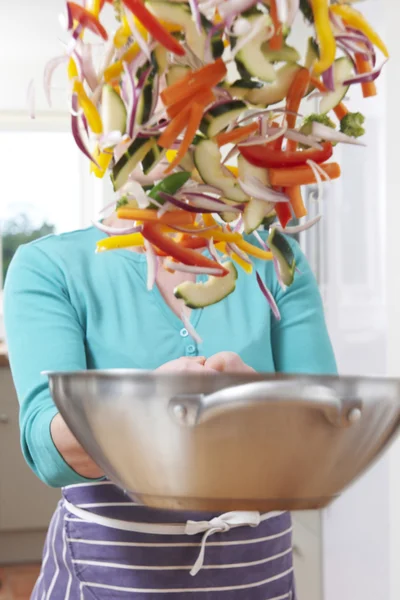 Cocinera arrojando verduras en la sartén oscureciendo su cara —  Fotos de Stock