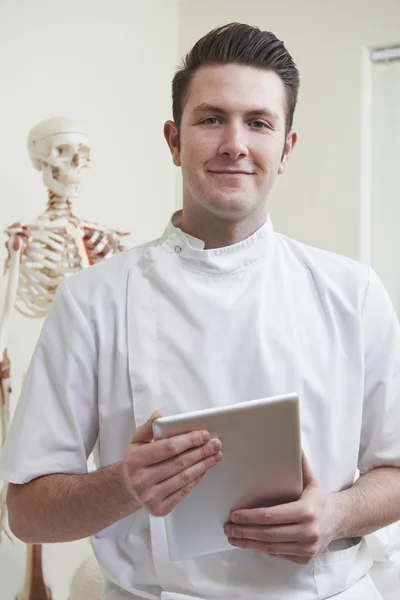 Portret van osteopaat In raadpleging van kamer met digitale Tablet — Stockfoto