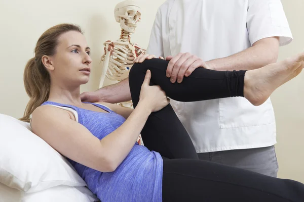 Osteopata maschio che tratta paziente femminile con problema all'anca — Foto Stock