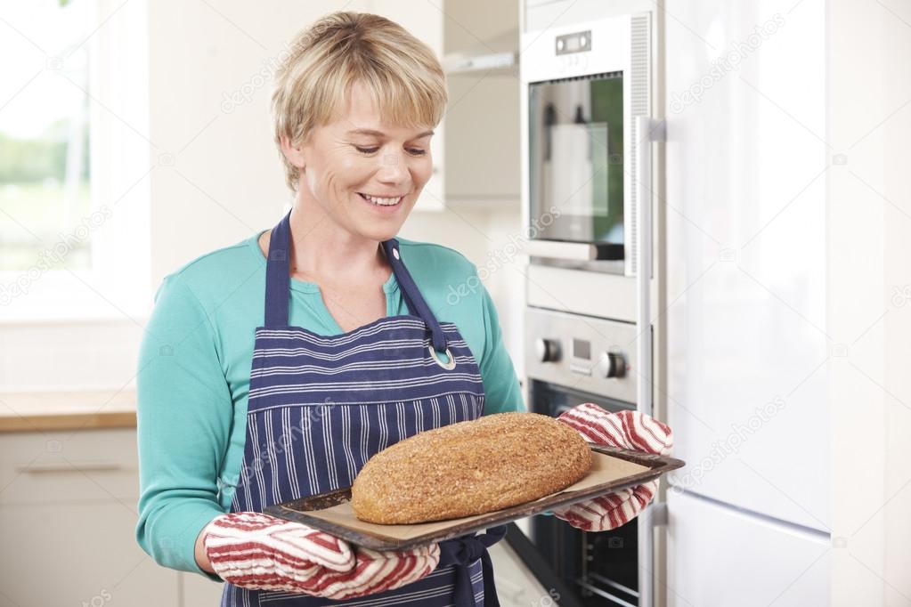 Woman Holding Tray With Home Made Loaf Of Bread