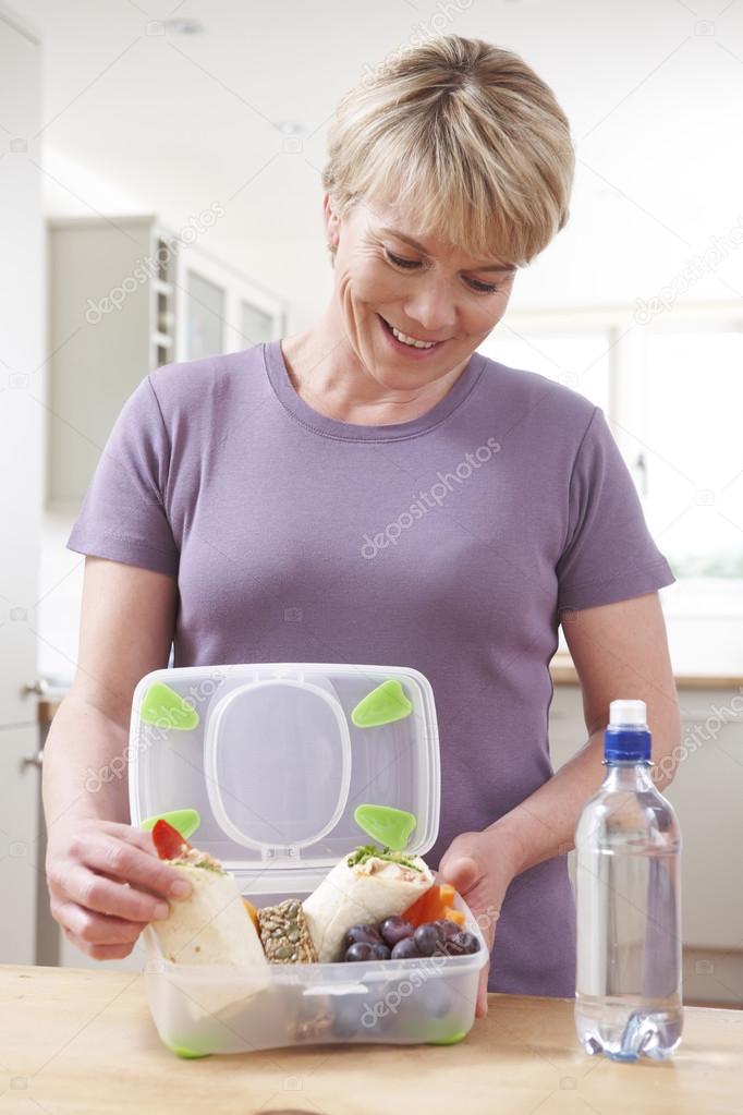 Woman Preparing Healthy Lunchbox In Kitchen
