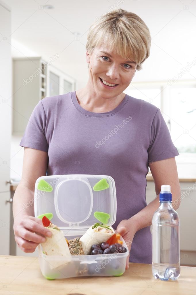 Mother Preparing Healthy Lunchbox In Kitchen