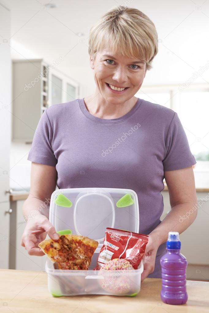 Mother Preparing Unhealthy Lunchbox In Kitchen
