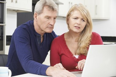 Worried Mature Couple Reviewing Domestic Finances clipart