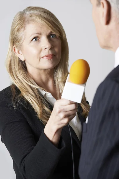 Журналистка с микрофонным интервью с бизнесменом — стоковое фото