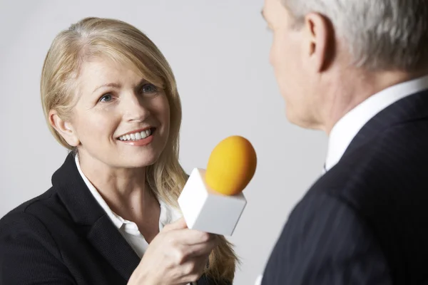 Periodista femenina con micrófono entrevistando a hombre de negocios — Foto de Stock