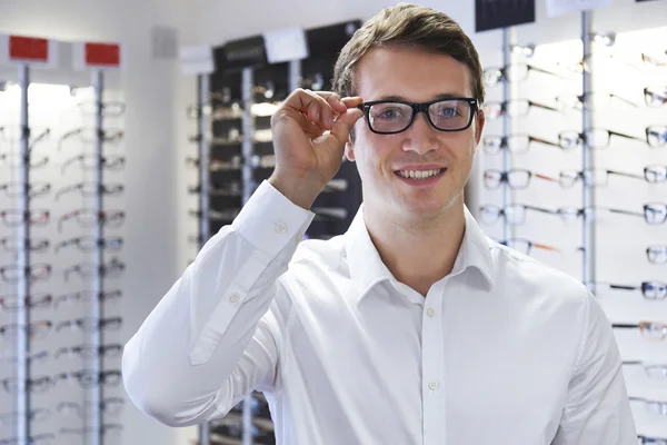 Hombre Elegir nuevas gafas en ópticos — Foto de Stock