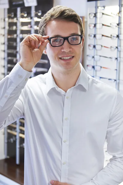 Ο άνθρωπος προσπαθεί με τα νέα γυαλιά σε οπτικούς — Φωτογραφία Αρχείου