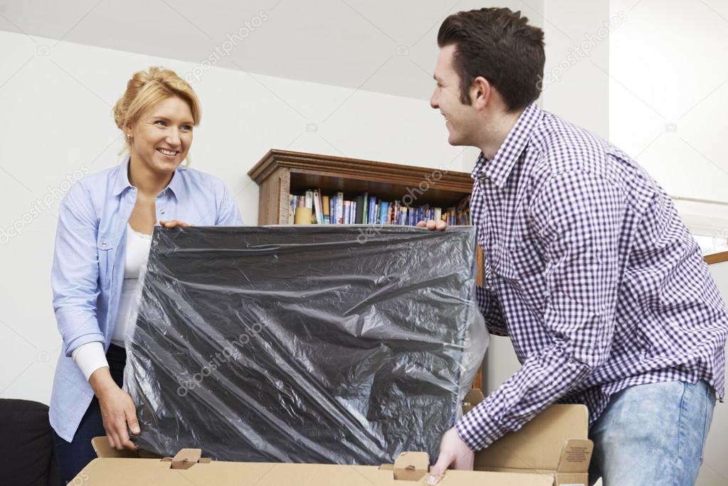 Couple Unpacking New Television At Home