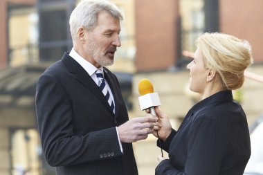 Female Journalist With Microphone Interviewing Businessman  clipart