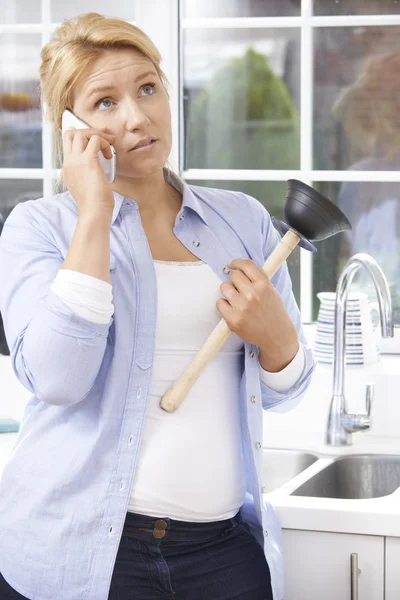 Femme frustrée appelant le plombier pour réparer l'évier bloqué à la maison — Photo