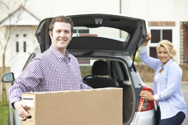 Paar lossen nieuwe televisie uit auto kofferbak — Stockfoto