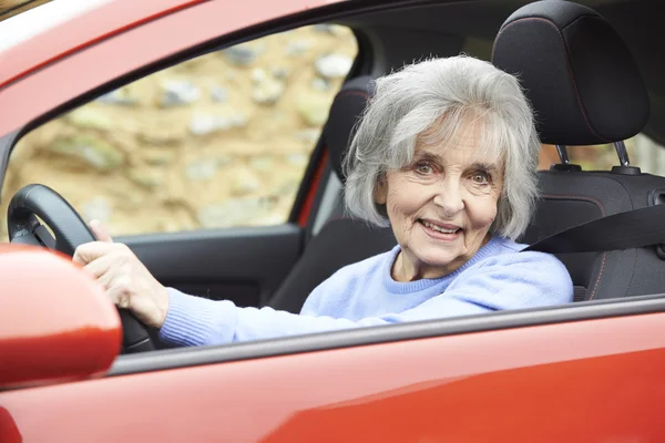 Portretul unei femei în vârstă zâmbitoare care conduce o mașină — Fotografie, imagine de stoc