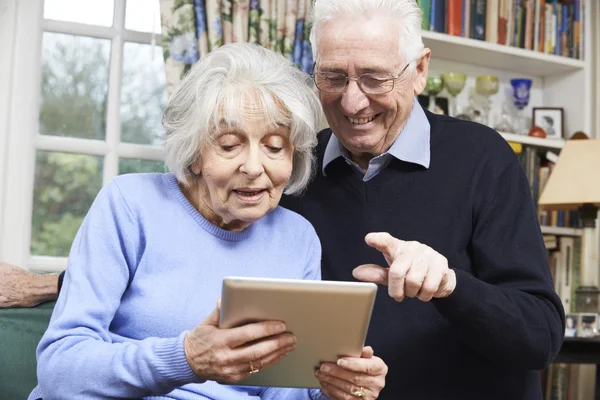 Casal sênior usando tablet digital em casa — Fotografia de Stock