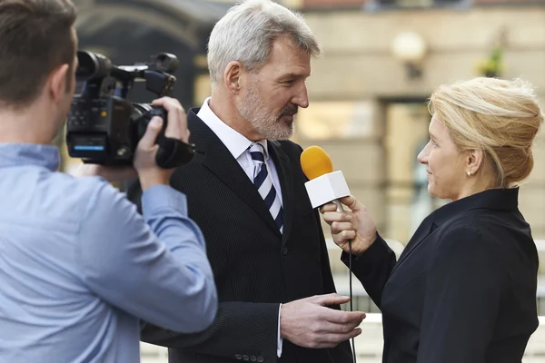 Journaliste féminine avec microphone Entrevue Homme d'affaires — Photo