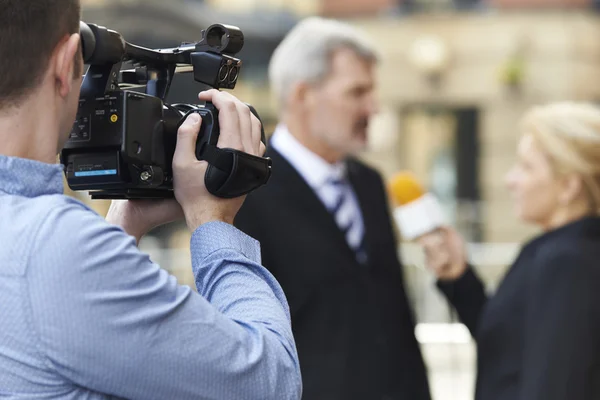 Camarógrafo grabando mujer periodista entrevistando a hombre de negocios — Foto de Stock