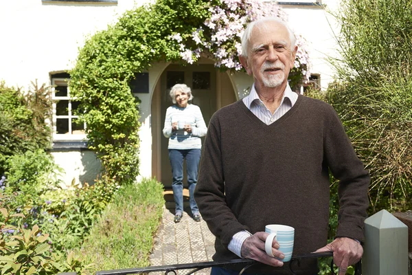 Coppia anziana in piedi in Cottage Garden Holding Coffee Cup — Foto Stock