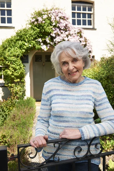 Donna anziana in piedi fuori grazioso cottage — Foto Stock