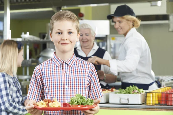 Alumno masculino con almuerzo saludable en la cafetería de la escuela — Foto de Stock