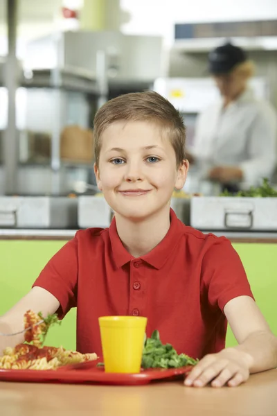 Mannelijke leerling zitten aan tafel In Schoolcafetaria eten gezond L — Stockfoto