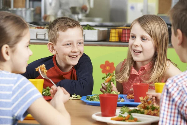 Grupo de Alunos sentados à mesa na Cafetaria Escolar Comendo Almoço — Fotografia de Stock