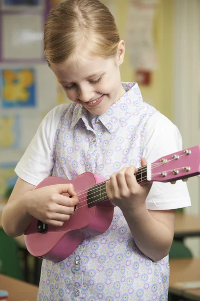 Chica aprendiendo a jugar Ukulele en la escuela lección de música — Foto de Stock