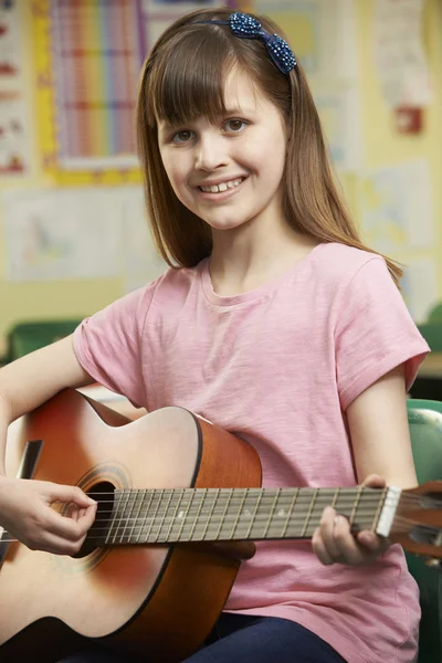 Chica aprendiendo a tocar la guitarra en la escuela lección de música — Foto de Stock