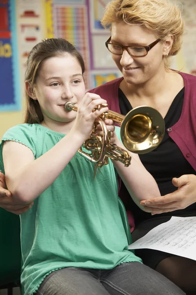 Lehrerin hilft Schülerin beim Trompeten-Spielen im Musikunterricht — Stockfoto