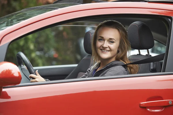 Женский водитель-подросток, выглядывающий из окна автомобиля — стоковое фото