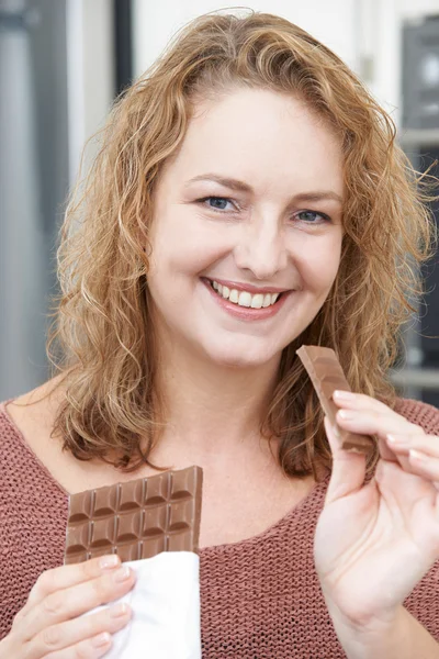 Glimlachend Plus grootte vrouw Bar van chocolade eten — Stockfoto