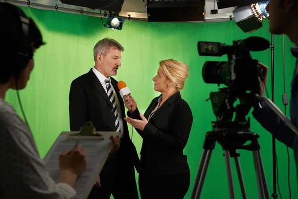Vrouwelijke presentator interviewen In televisiestudio met bemanning In — Stockfoto