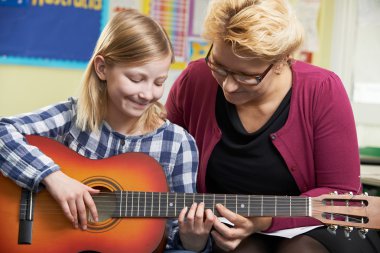 Müzik dersi gitar çalmayı öğrenci yardımcı öğretmen